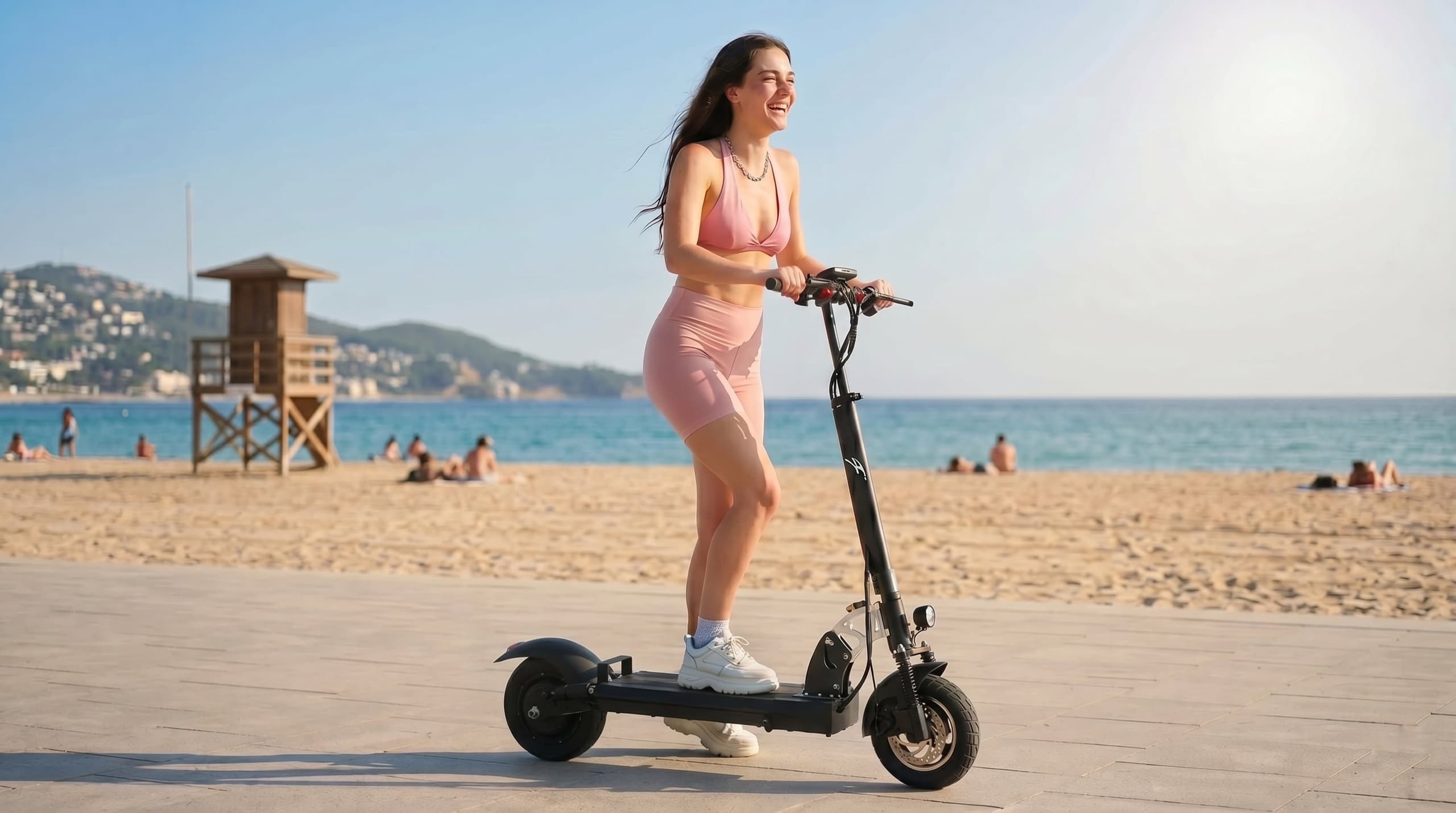 Rider smiling on an F1 scooter along a seaside boardwalk at midday